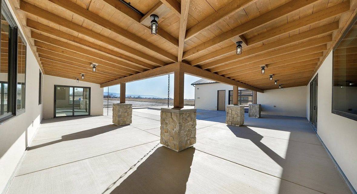 Covered patio with timber beams and stone column bases